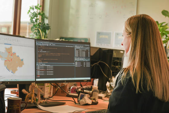 An image showing a woman working on computer coding to create a map of human-elephant interactions