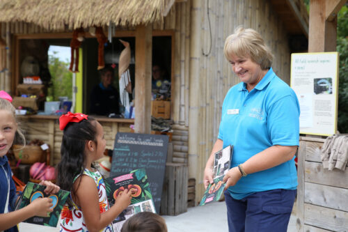 A volunteer at Chester Zoo speaking to young children 